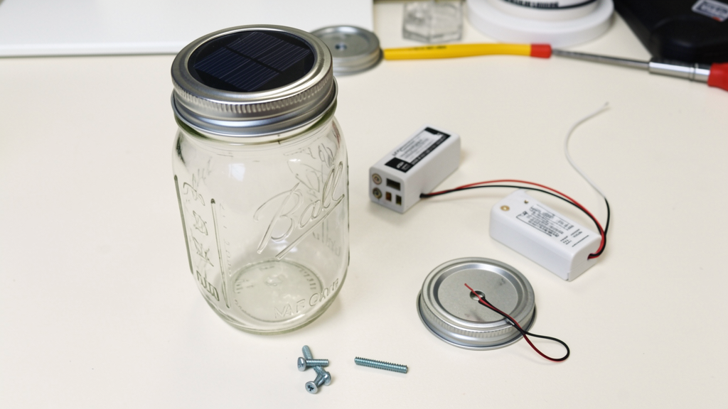 Step-by-step mason jar solar light assembly illustration showing drilling the lid, mounting the solar cap, inserting the battery, and closing the jar.